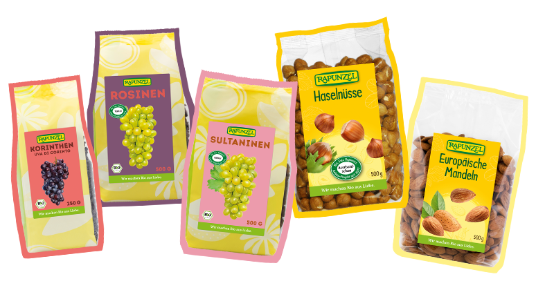 Rapunzel Sultaninen, Rosinen und Korinthen sowie Mandeln und Haselnüsse auf gelbem Hintergrund dargestellt